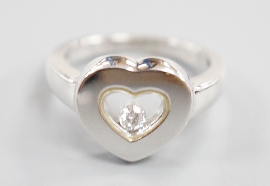 A modern 750 white metal and 'floating diamond' heart shape dress ring, size M, gross weight 6.4 grams.